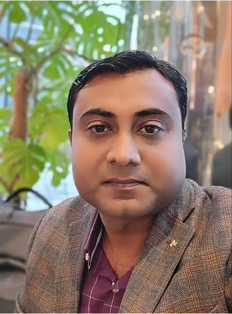 Man in blazer with plants in background