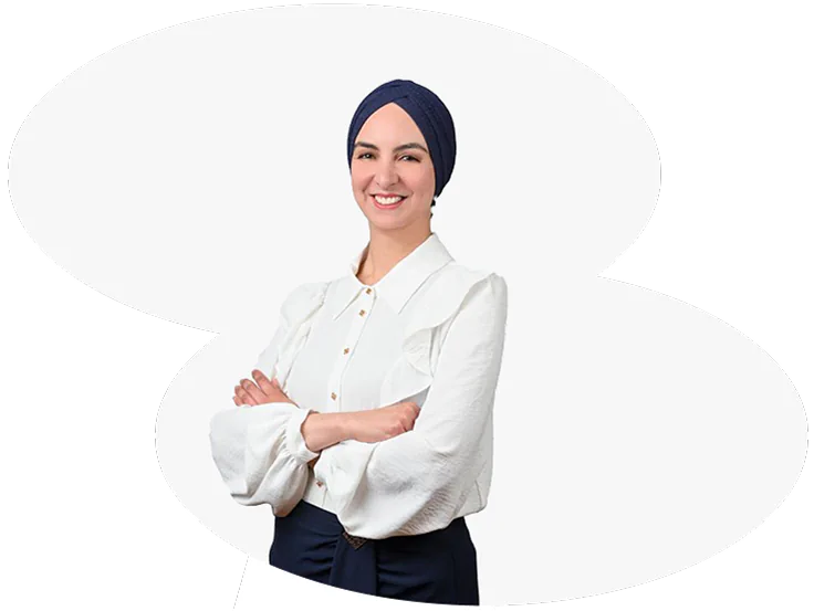 Smiling woman in white blouse with crossed arms.